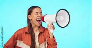 Megaphone, scream and angry woman in studio for change, justice and vote, power and transformation on blue background. Bullhorn, speaker and shouting lady with speech or noise, news or announcement