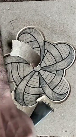 Carving intricate floral pattern on grey stone with sharp tool