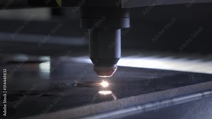 Industrial Laser cutting on wood, cutting a pattern on a plywood sheet and moving slowly, close up. A large technological machine burns through a wooden board. New technologies in woodworking.