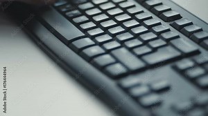 Office concept: keyboard closeup, man hands tapping on black keyboard with roman and cyrillic letters, table in office background. Shot on RED Epic Camera