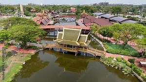 Aerial views of ancient Thai temples nestled in lush greenery and tranquil waters. These magnificent structures showcase intricate architecture, offering a serene glimpse into Thailand's rich cultural