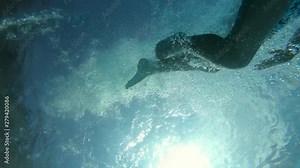 Boy plunging in water, shot from below. Slow motion shot at 100 fps
