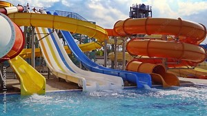 Colorful waterslides and pool. Multicoloured giant waterslide at public swimming pool
