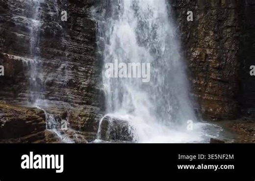 Waterfall falling from the high cliff in spring overcast day Stock Video Footage - Alamy