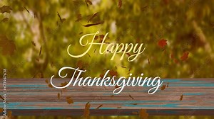 Animation of happy thanksgiving text over leaves and wooden table against trees