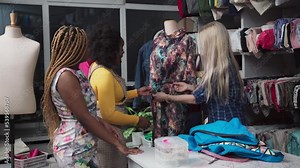 A seamstress shows a dress on a mannequin to apprentices at a tailor school.
