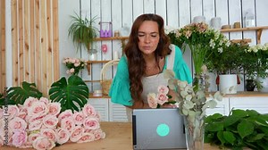 The florist teaching how to make a bouquet using digital tablet. Online lesson.