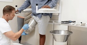 Technician fitting prosthetic leg for patient in medical lab setting. Healthcare, prosthetics, rehabilitation, orthopedics