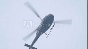 Helicopter flying in the sky low angle shot footage. Helicopter in flight. Capable of moving vertically and horizontally, the direction of motion being controlled by the pitch of the rotor blades.