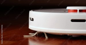 Smart Robot Vacuum Cleaner with lidar on wood floor. Robot vacuum cleaner performs automatic cleaning of the apartment. 4K slow motion 100 fps, ProRes 422, 10 bit