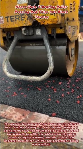 Heavy Duty Vibrating Roller Pressing Red Chips Into Black Tarmac