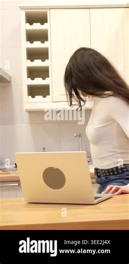 Joyful multiracial couple sitting at a wooden kitchen island, happily browsing content on a digital tablet, sharing a moment of connection and entertainment in their modern home Stock Video Footage - Alamy