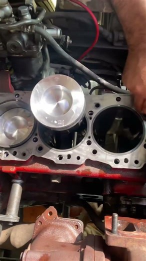 Massive six-cylinder diesel engine piston ring installation. Precision, and satisfying engine work