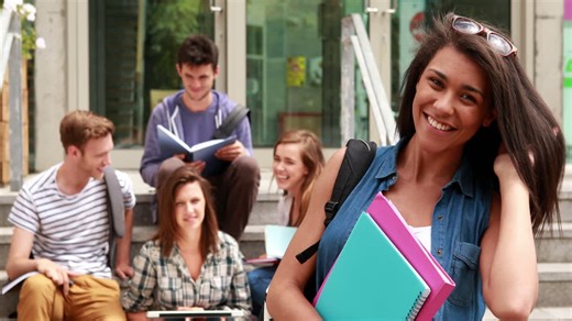 Pretty student posing and friends studying behind her | Premium Stock Video Footage