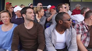 Mexican Wave. Enthusiastic crowd of sports fans. Could be a scene from stadium crowd at the olympics, tennis, American football, soccer match or baseball. People of all ages cheering and smiling.