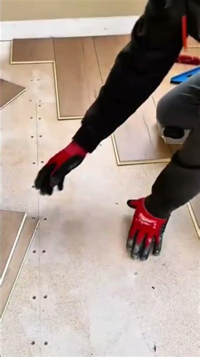 Worker installing interlocking wood-look laminate vinyl flooring planks
