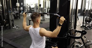 Man training on sports simulator and lifting weights in gym 4k movie slow motion. Arm muscle strength exercises concept