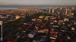 Aerial view of Manila's skyline at sunset, featuring Manila Cathedral, bustling streets, and the port and its facilities