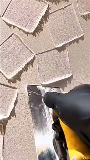 Applying textured plaster on the wall surface using a metal spatula carefully now