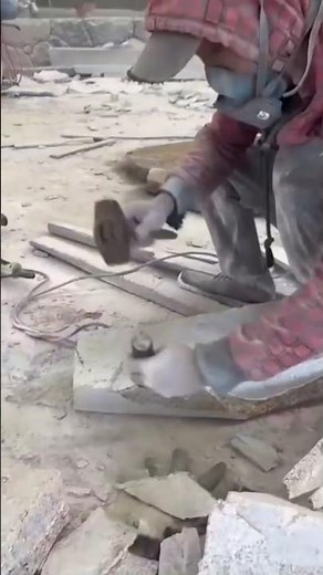 Wood Craftsman Skill using a traditional adze to strip the rough bark off a massive log.