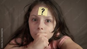 Confused child with question mark. A view of confused little girl think about her question on the forehead.