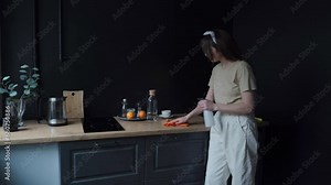 A housewife cleans the kitchen from leftover food. Caucasian girl cleans the kitchen with a spray and a microfiber cloth. The housekeeper cleans up the apartment. Daily household chores concept.