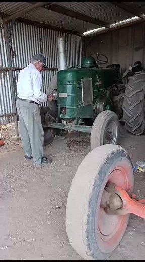 Repairing an Old Green Tractor in a Rustic Shed