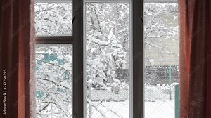 winter outside the window,Looking Out Of A Window To Heavy Falling Snow Outside In Winter