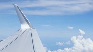 view inside airplane aircraft through window with wing view while flying in sky over puffy cloudy in sunny day,Airplane Wings with blue sky travel vacation holiday background