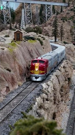 A classic Santa Fe Streamliner rounds the precarious cliffside track of Midway Loop in O scale