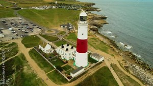 Landmark Portland Bill Lighthouse on picturesque British rugged Jurassic coast aerial orbit left view