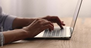 Close up young business woman typing on laptop keyboard, preparing project report or presentation, texting email for colleagues, communicating with clients, using applications or web surfing.