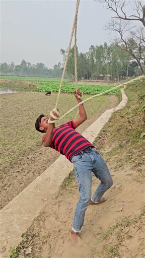 A man carries a rope in his hand.
