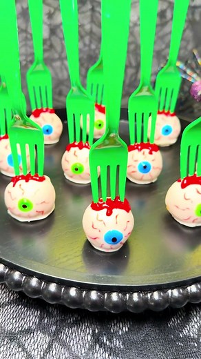 Fresh Bloody Eyeballs 🩸👀 Eye see you… these eyeball cake pops are watching your every bite.👁️ Would you take a bite? 👻 Ingredients: 8 frosted soft sugar cookies (store bought) 1 bag Ghirardelli white coating wafers 1 ea blue, green, black and red decorating gel One red food, coloring marker Directions: Add cookies to a table top mixer, and mix until it forms together. (if too dry add 1 teaspoon of water at a time until the dough comes together) Roll into 1oz balls and freeze for 20 minutes t