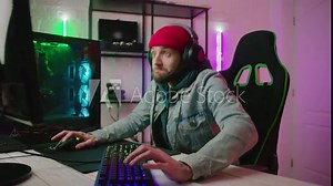 Gamer playing online video game in pc at home. Colorful Neon Led Lights. Play Cyber Gaming Tournament and Have live stream.