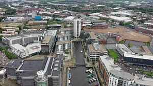 Aerial drone footage taken in the city of Leeds in West Yorkshire in the UK showing the area known as the Leeds Docks with the canal and high rise building apartments