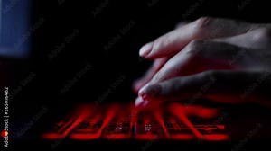 hacker girl's hand typing on keyboard with red backlight