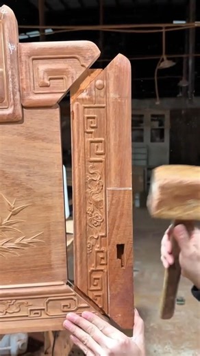 assembling a brown wood manually using a wooden mallet tool for a very neat craft finishing work