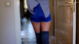 Pretty girl in denim shorts walking down the hall . She danced while...