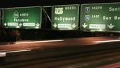 timelapse of cars under Hollywood freeway sign