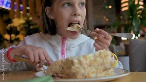 Beautiful girl sitting in cafe and eating creamy sweet cake. 4k video footage