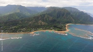 Tunnels beach, Kauai, Hawaii, USA. Breathtaking Aerial shot along the coast with amazing white sand beach and tropical coral reef lagoon towards beautiful green mountains.