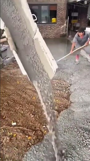 Pouring fresh concrete mix from a cement truck chute to create a solid and even building foundation