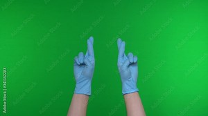 Good luck symbol fingers crossed human hands. Hands gesture in medical gloves. Coronavirus pandemic (Covid-19). Chroma key, Isolated chromakey background, Green screen