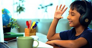 Studious Indian Asian Boy Attending Online Class at Home Using Computer, Learning Virtually and Communicating with Teacher, Highlighting Modern Education, E-Learning, and Technology in Daily Life
