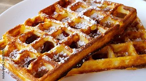 Waffle with maple syrup topping and sugar powder, delicious sweet dessert.