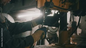 A worker works on a metal drilling machine in a workshop. Metallurgy production. A machinist operating a traditional non-CNC milling machine in a machine shop. Operates an industrial machine. 4K
