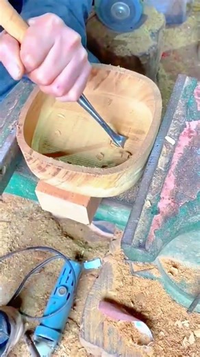 using a metal chisel tool to hollow out a wooden bowl for creating a beautiful handmade art piece