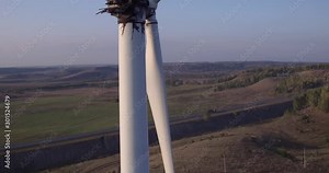 Wind energy farm turbine destroyed / old damaged by fire after a lightning strike / Windmill, energy production on hilly lanscape at autumn sunset - Aerial drone view