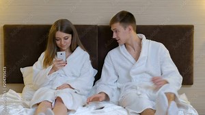 relationship distrust jealousy and suspicion. woman snooping in her boyfriends phone checking for texts and suspecting infidelity. girlfriend riend prying into guys personal space